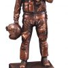 A bronze statue of an Air Force airman in full gear with his helmet in hand. The bronze statue is mounted on black base.