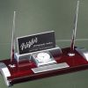 A desk pen set made with piano finished rosewood & chrome silver metal. The set includes a clock, business card holder, 2 silver pens and a silver engraving plate that is personalized with our full color process.