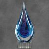 Glass Raindrop with multiple blue colors throughout, mounted on clear glass base,