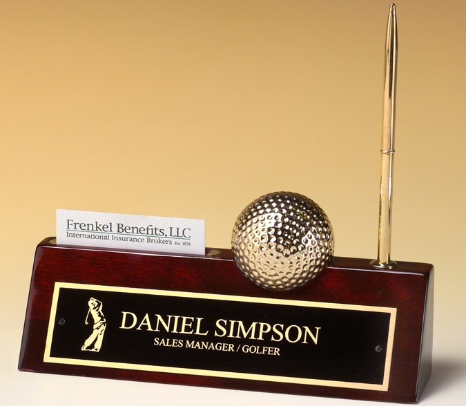 This is our Golf Name Plate that's made with piano finish rosewood. It includes a business card holder, gold golf ball that has a clock inside of it, a gold pen & of course a black & gold engraving plate for personalization. 