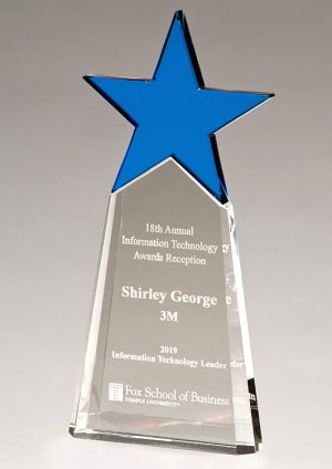 A crystal trophy with a blue crystal star at the top and clear crystal below that has laser engraving personalization on it. The clear crystal gets wider at the bottom so it can stand freely without falling over.