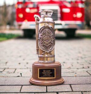 A bronze Antique Fire Extinguisher Trophy. The detailed artwork on the front depicts a classic steamer Maltese Cross and the artwork on the back shows a old steamer at a fire scene. It's mounted on a solid walnut base that includes a black brass engraving plate that laser engraves gold.