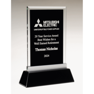 A rectangular black glass award made with a beveled rectangle piece of glass. The middle area is black so that it can be personalized with laser engraving. It's mounted on a black glossy base with a silver bracket connector at the top. The award is personalized with a Mitsubishi Electric logo at the top and words of appreciation for an employee that worked there for 20 years.