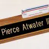 Our Walnut Desk Name Plate With Business Card Holder features an 8" walnut desk wedge made from 100% solid walnut. The top has a place cut out to put display your business card, while the front has a black & gold engraving plate for personalization. This specific one is personalized in gold text for Piece Atwater III. This 535BK is 2.5" x 8" in size and holds 3.5" long business cards.