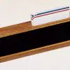 Walnut Desk Name Plate With Business Card Holder shown here with no engraving on the front. This 535BK desk name plate features a business card on top and a black engraving plate on the front for personalization. It measures 2.5" x 8" in size and includes free engraving.