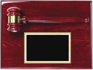 A solid rosewood board that is coated in a glossy piano finish. At the top of the rosewood plaque is a rosewood gavel with a gold gavel band. Below is a black engraving plate with a gold boarder.