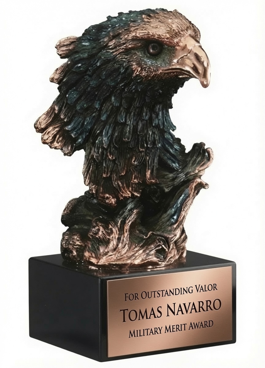 A detailed bronze-finished bald eagle head bust sculpture with intricately textured feathers, sharp beak, and a fierce, piercing gaze. The majestic sculpture is mounted on a sleek black rectangular base featuring a gold engraving plate that reads: 'FOR OUTSTANDING VALOR TOMAS NAVARRO MILITARY MERIT AWARD.' This 10″ tall eagle sculpture includes free engraving or full color personalization.
