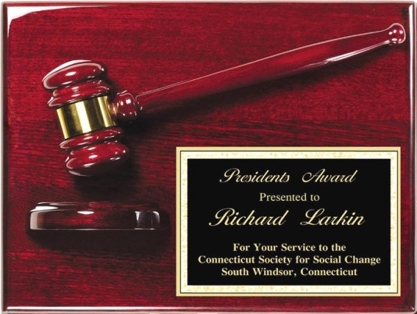 A solid rosewood board coated in piano finish. On the rosewood plaque is a rosewood gavel & sounding block. In the bottom right hand corner is a black & gold engraving plate. It has words of appreciation to Richard Larkin from the Connecticut Society for Social Change.