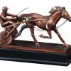Our Sulky Harness Racing Statue featuring a resin statue that is coated with a thin metal layer for added strength & detail. I shows a race horse pulling a sulky & jockey. The jockey has a helmet on and a whip in hand. It's mounted on a black base that includes a bronze engraving plate for personalization. This RFB031 Sulky Statue is 12.5" long, weighs7.3 lbs and includes both free engraving & free shipping.