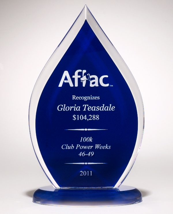 A blue acrylic award in the shape of a flame. It has engraving on the blue middle part with a logo & text and the base is blue acrylic as well.