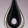 Black Raindrop Glass Art Sculpture GLSC32, Raindrop shaped piece of glass with hole in middle, mounted on a black base