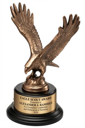 1295 XL Eagle Statue featuring a detailed antique bronze-finished eagle with wings majestically outstretched, mounted on a black piano-finish round base with a gold engraving plate. The plate is engraved with: 'EAGLE SCOUT AWARD / Presented to ALEXANDER J. RAMIREZ / For Exemplary Leadership and Dedication to Scouting / 2026'. This 9″ tall (3″ x 9″, approx. 5 lbs) premium trophy is a powerful symbol of achievement, leadership, and patriotism.