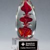 2255 Blood Glass Art Award, Egg shaped piece of glass with red color drops throughout, mounted on glass base