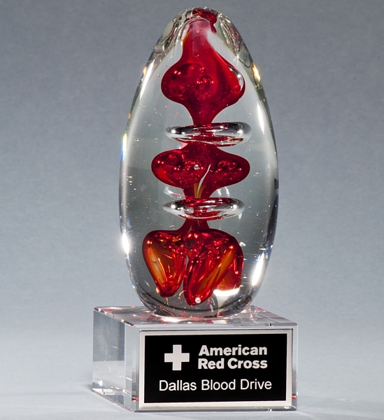 2255 Blood Glass Art Award, Egg shaped piece of glass with red color drops throughout, mounted on glass base