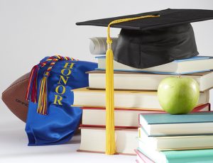A photo of collage of education items such as a diploma, graduation hat, graduation sash, books and an apple