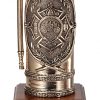 An antique bronze fire extinguisher with extreme detail design. The design in the middle features a firefighter Maltese cross with a classic firefighter steamer in the middle. It's mounted on a walnut base with a black brass engraving plate for personalization.