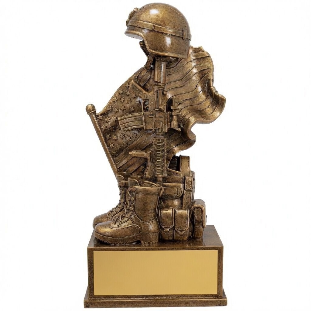 a detailed bronze sculpture of a kneeling soldier in full combat gear with helmet, boots, tactical vest, and rifle, holding a waving American flag. Mounted on a bronze rectangular base with a blank gold engraving plate. Shown in a straight frontal view.