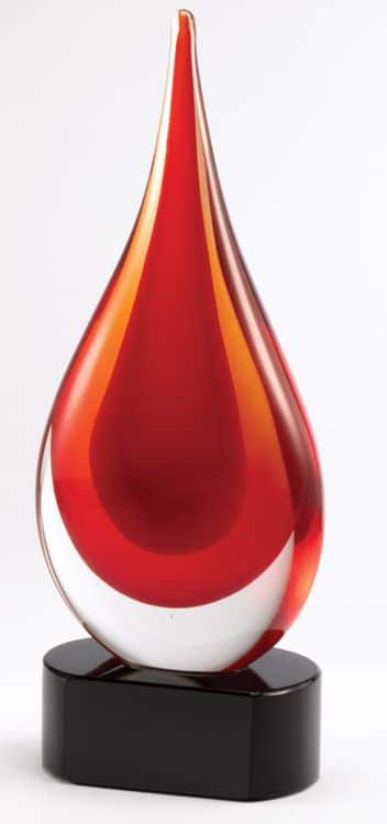 Glass rain drop with 2 hues of red in it mounted on a black glass base.