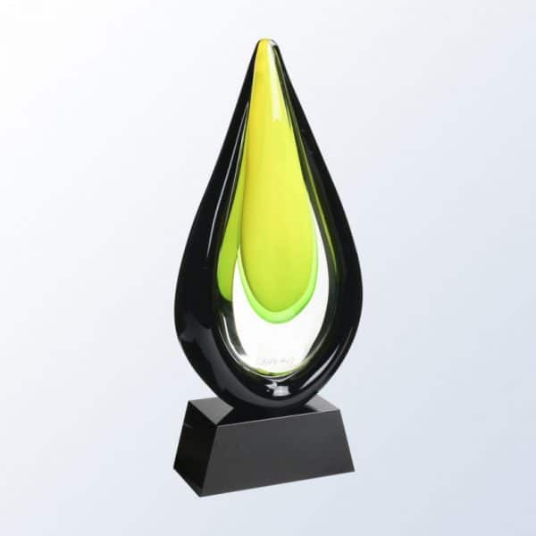 Glass water drop shaped piece of glass with lemon-lime themed colors on the inside and black on the outside edge. It's mounted on a black glass base with an engraving plate for personalization.