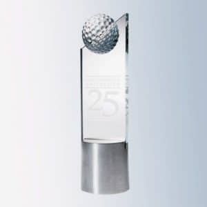 A trophy with slanted glass for engraving that has a solid glass golf ball at the top. It's mounted on a cylinder silver base for a contemporary look.