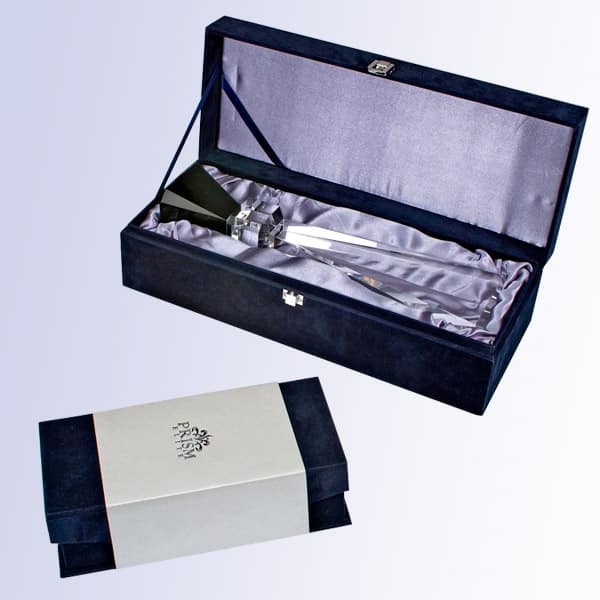 A blue deluxe gift box with silver satin lining on the inside. The box has a silver latch on the outside. There's also a closed photo of the deluxe gift box with a white sleeve over it to help keep it shut.
