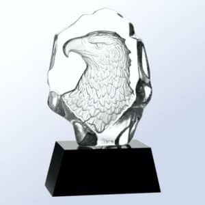 A piece of jaded crystal with an eagle bust head carved out in the back. It's mounted on a black crystal base.