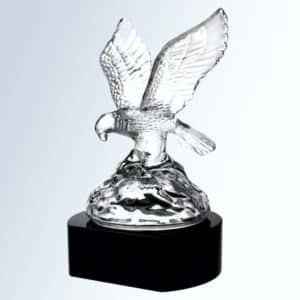 A clear crystal eagle with his wings spread as he soars through the air. It's mounted on a black crystal base.