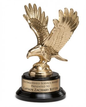 Gold Eagle Statue 1298 XL featuring a striking, highly detailed gold-finished metal eagle with wings dramatically spread in a majestic flight pose, mounted on a sleek piano-finish black round base with a gold engraving plate. The plate is engraved with: 'DISTINGUISHED SERVICE AWARD / PRESENTED TO / CAPTAIN ZACHARY RITTER'. This premium eagle statue is 9″ tall (approx. 4.1 lbs)