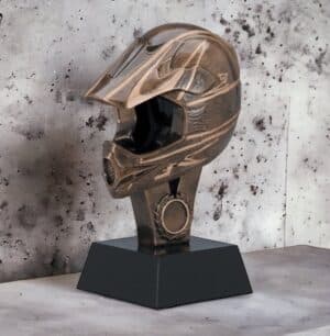 A motocross trophy that's made from a resin motocross helmet. It's mounted on a black base that includes an engraving plate for personalization.