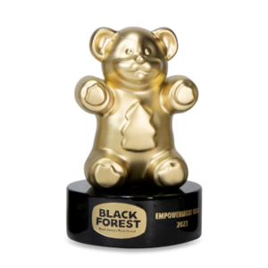 A trophy made from a giant gold gummy bear that is mounted on a black base. The base is personalized with a laser engraved logo & text. 