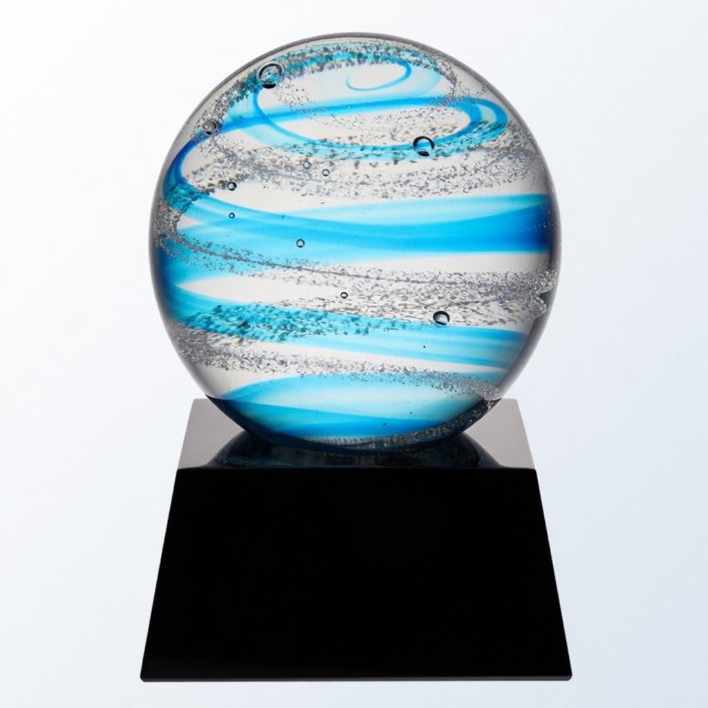 A stunning hand-blown glass orb featuring vibrant blue and white swirling patterns with sparkling bubbles and silver accents. Mounted on a sleek black base, this modern and elegant piece is perfect for personalized engraving and unique recognition awards.