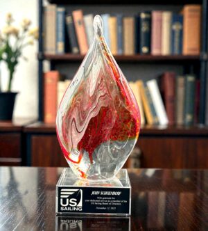 Our Burnt Orange Flame Twist Art Glass Award features a twisting piece of glass with flamed themed colors inside. This photo shows the front of the tiem sitting on a dark wood desk. It’s mounted on a clear glass base that includes an engraving plate for personalization. It also comes in a deluxe gift box. The GLSC10 is 4" by 10.75" and weighs 5 lbs.