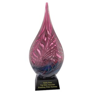 Our Sailors Sunset Art Glass Award features a raindrop shaped piece of art glass with hues of pink at the top & an assortment of darker colors towards the bottom. It's mounted on a black glass base with an engraving plate for personalization. This AGS65 art glass award is 7" x 16.5" in size, weighs 14 lbs. & is packaged in a deluxe gift box.
