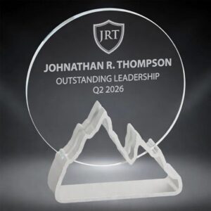 Silver Expedition Glass Award featuring a large clear circular crystal disc mounted on a frosted silver mountain range base. Engraved with a JRT shield logo, 'Johnathan R. Thompson', 'Outstanding Leadership', and 'Q2 2026'