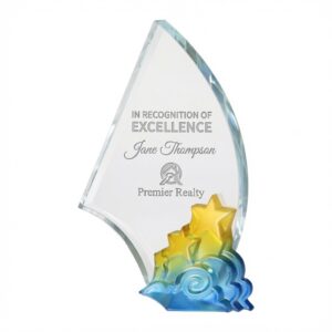 Celestial Achievement Award – an elegant 8.25 inch tall crystal trophy featuring a tall, curved clear crystal sail shape with a vibrant, multi-colored base of yellow stars rising from blue and green clouds. Laser engraved in the clear upper section with the text “IN RECOGNITION OF EXCELLENCE” and “Jane Thompson”, along with a real estate logo and “Premier Realty”. This 3 lb premium crystal award is perfect for recognizing outstanding achievement in real estate. Displayed on a pure white background.